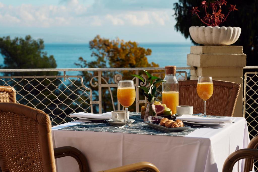 a table with glasses of orange juice and a plate of food at Hotel Lovran in Lovran