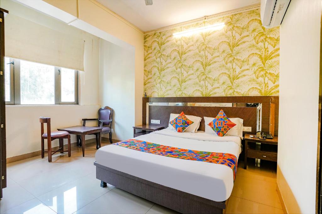 a bedroom with a bed and a desk and a table at FabHotel Gargi Deluxe in Pune