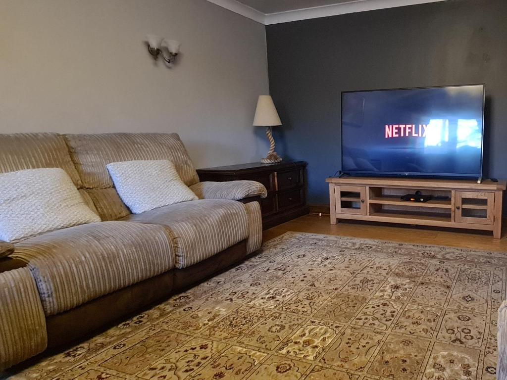 a living room with a couch and a television at Spacious, 5 bed house for 9 in Chester in Chester