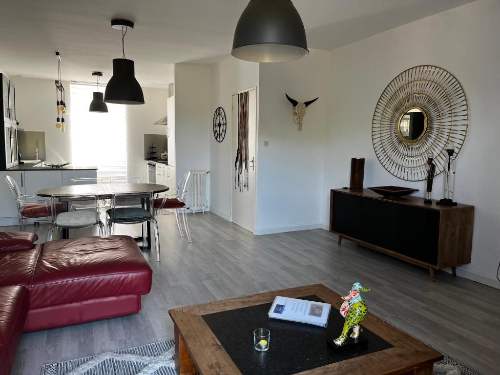 a living room with a couch and a table at Chez Monsieur le directeur de la poste in Piégut-Pluviers