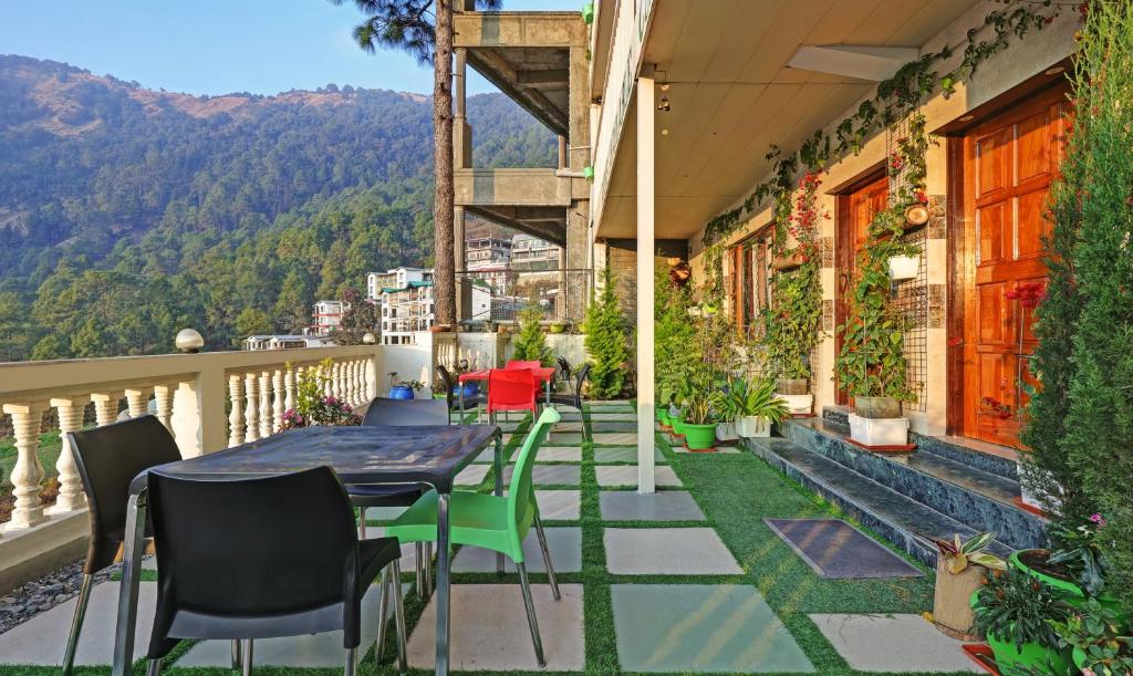 a patio with a table and chairs on a balcony at Itsy By Treebo - Drishti Cottage Near View Point in Nainital