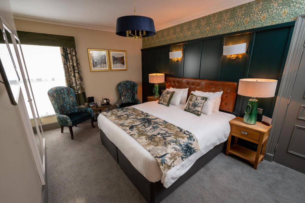 a hotel room with a bed and a desk and chairs at Riverside Hotel by Chef & Brewer Collection in Burton upon Trent