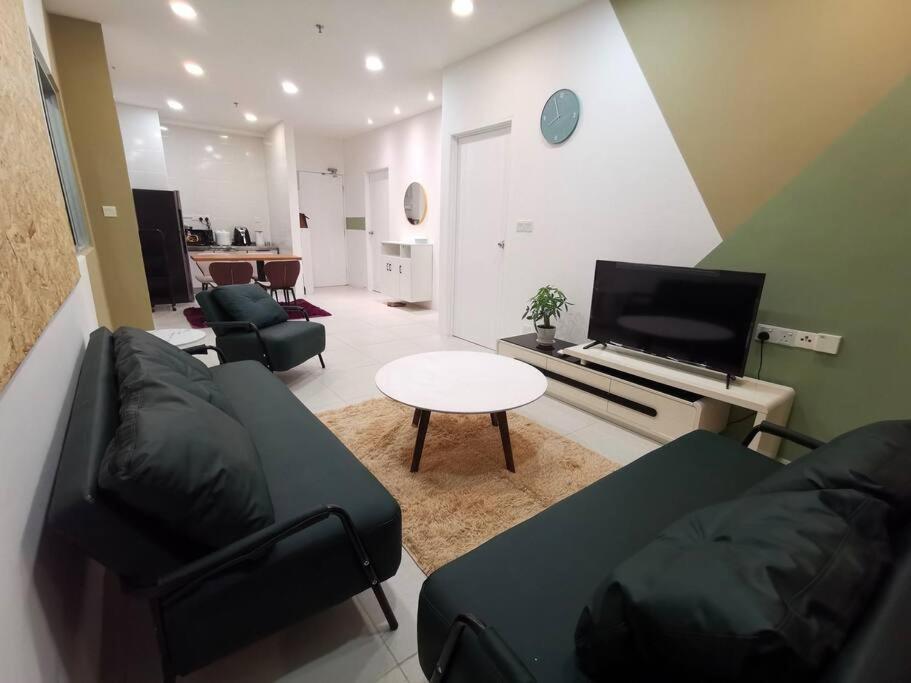 uma sala de estar com um sofá e uma televisão em Wincy Home Metrocity Kuching-N em Kuching