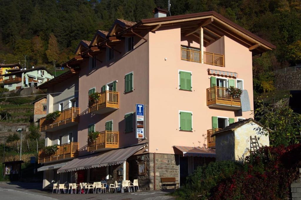 a large building with balconies and tables and chairs at B&B SEGONZANO in Segonzano