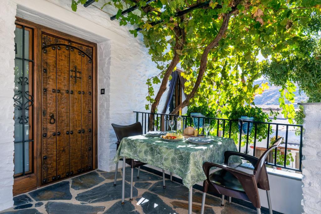 einen Tisch und Stühle auf einer Terrasse mit einem Baum in der Unterkunft Casa Antonia Capileira La Alpujarra in Capileira