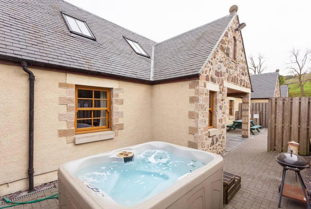 a large bath tub in front of a house at Appletree Cottage at Williamscraig Holiday Cottages in Linlithgow