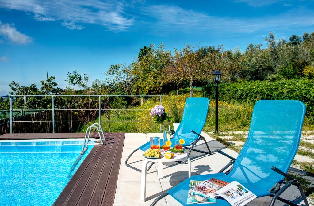 un patio avec deux chaises et une table à côté d'une piscine dans l'établissement Corinna, à Massa Lubrense