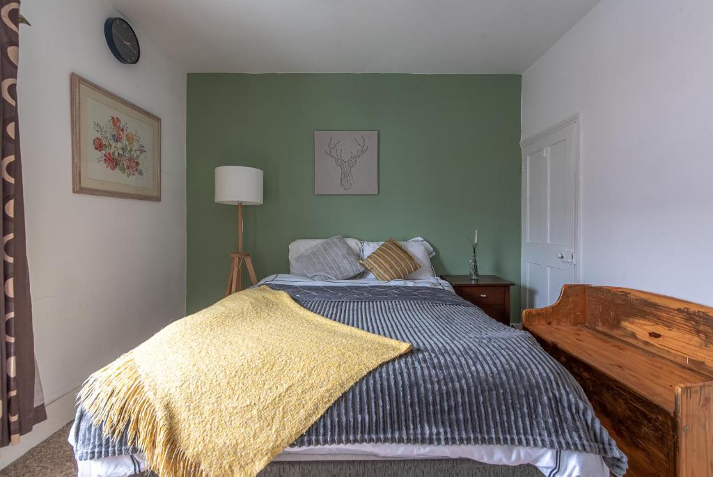 a bedroom with a bed with a blanket on it at Woodside House - 4 Bed Town House - Central Reading - Free Parking in Reading