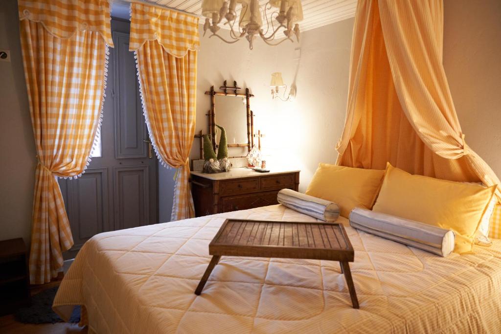 a bedroom with a bed with a table on it at Dandy Villas Dimitsana - a family ideal charming home in a quaint historic neighborhood - 2 fireplaces for romantic nights in Dimitsana