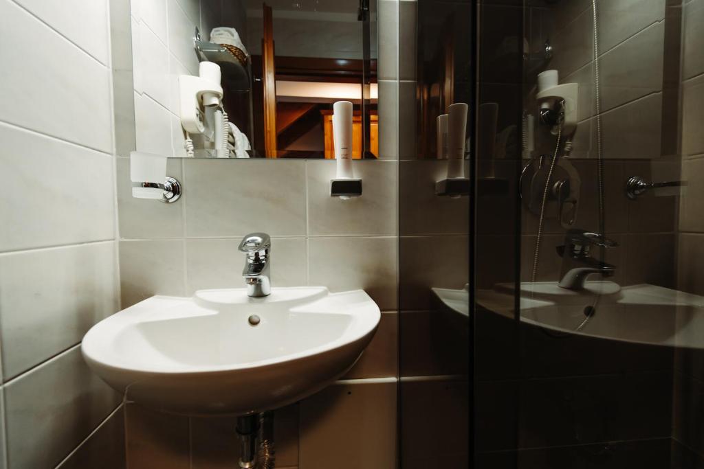 a bathroom with a sink and a mirror at Boutique Damiani in Sibiu
