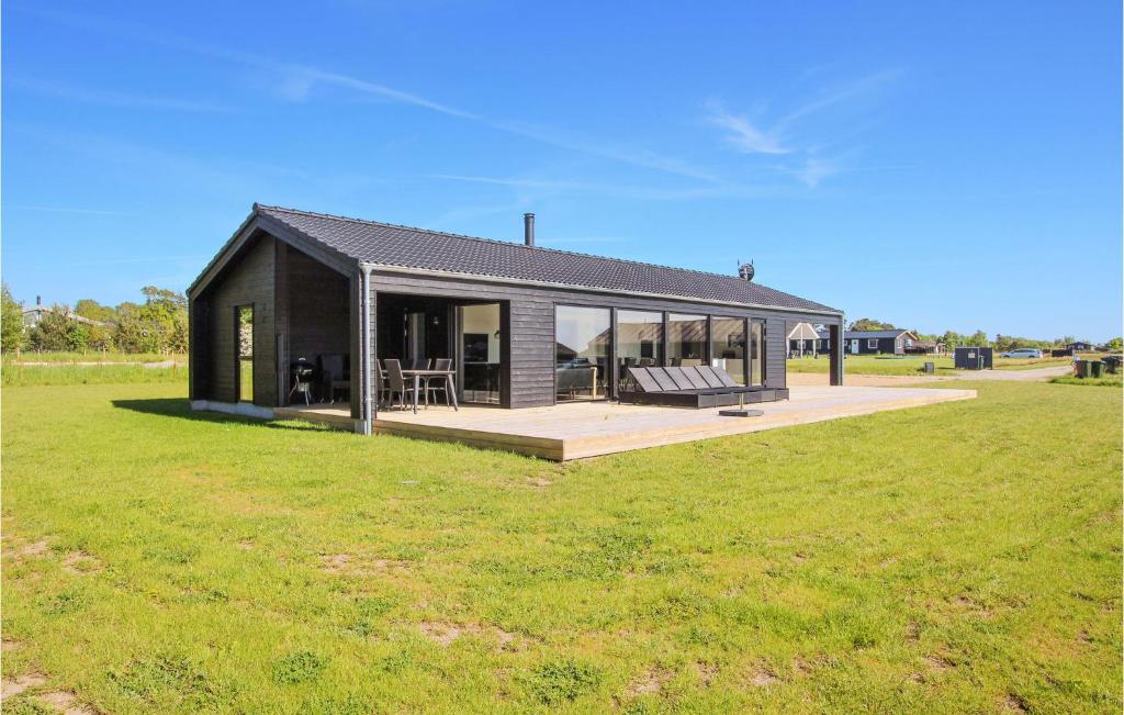 a black house with a large green field at Cozy Home In Samsø With Sauna in Nordby