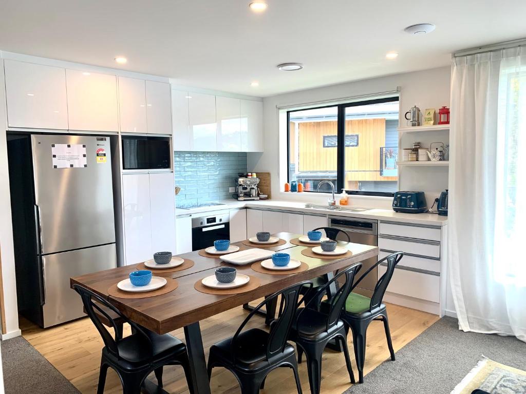 a kitchen with a table and chairs and a refrigerator at MyHolidays - The Four Seasons Queenstown in Queenstown