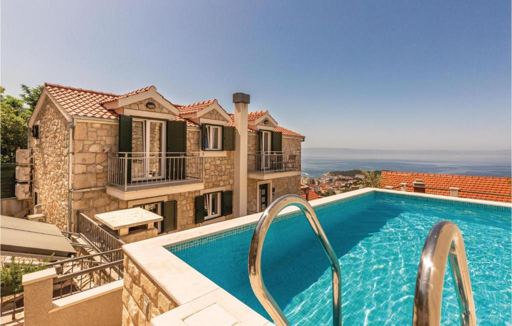 a swimming pool in front of a house at Nice Home In Makarska With Heated Swimming Pool in Makar