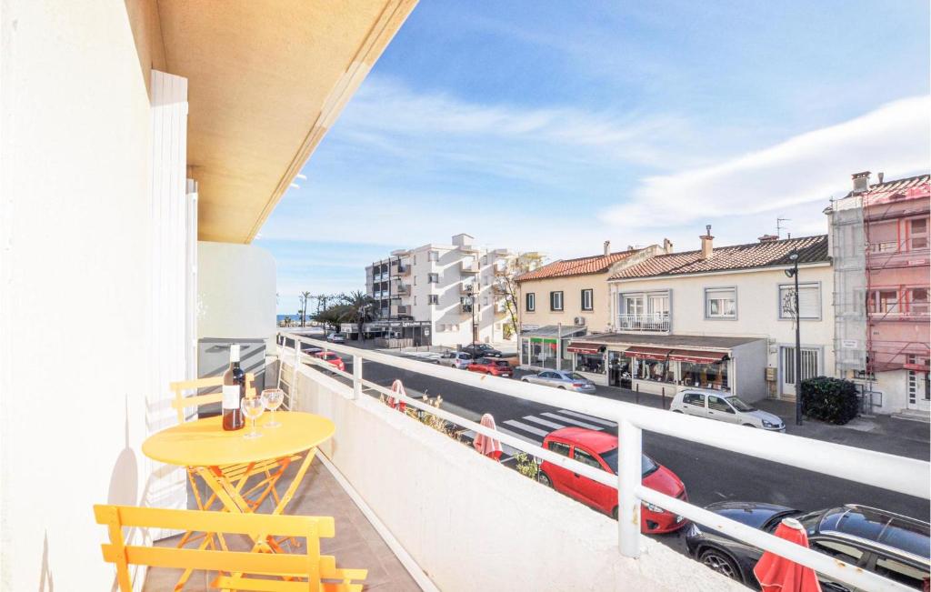 a balcony with a table and a view of a train at Amazing Apartment In Saint Cyprien Plage With Wifi in Saint-Cyprien-Plage