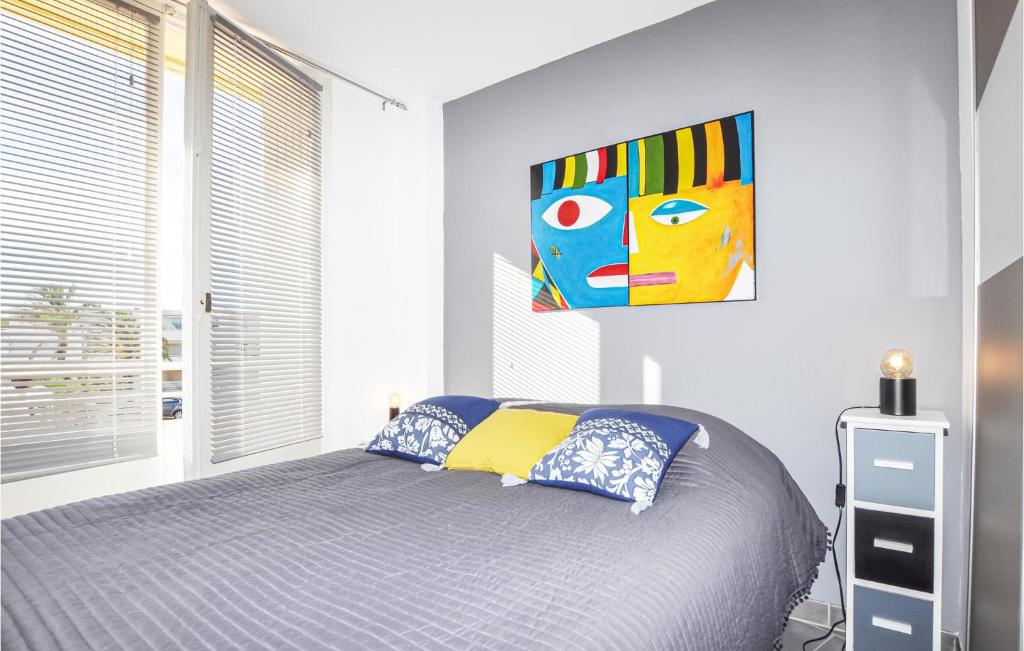 a bedroom with a bed and a painting on the wall at Amazing Apartment In Saint Cyprien Plage With Wifi in Saint-Cyprien-Plage