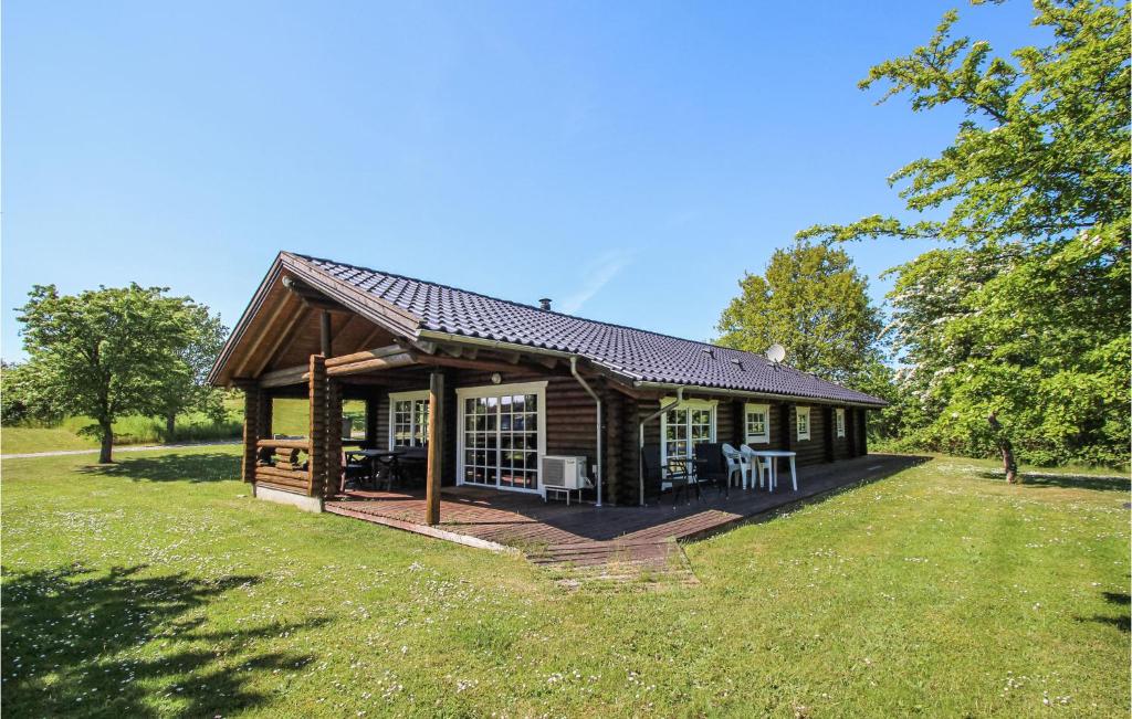 a log cabin with a deck in the grass at 3 Bedroom Stunning Home In Sams in Onsbjerg