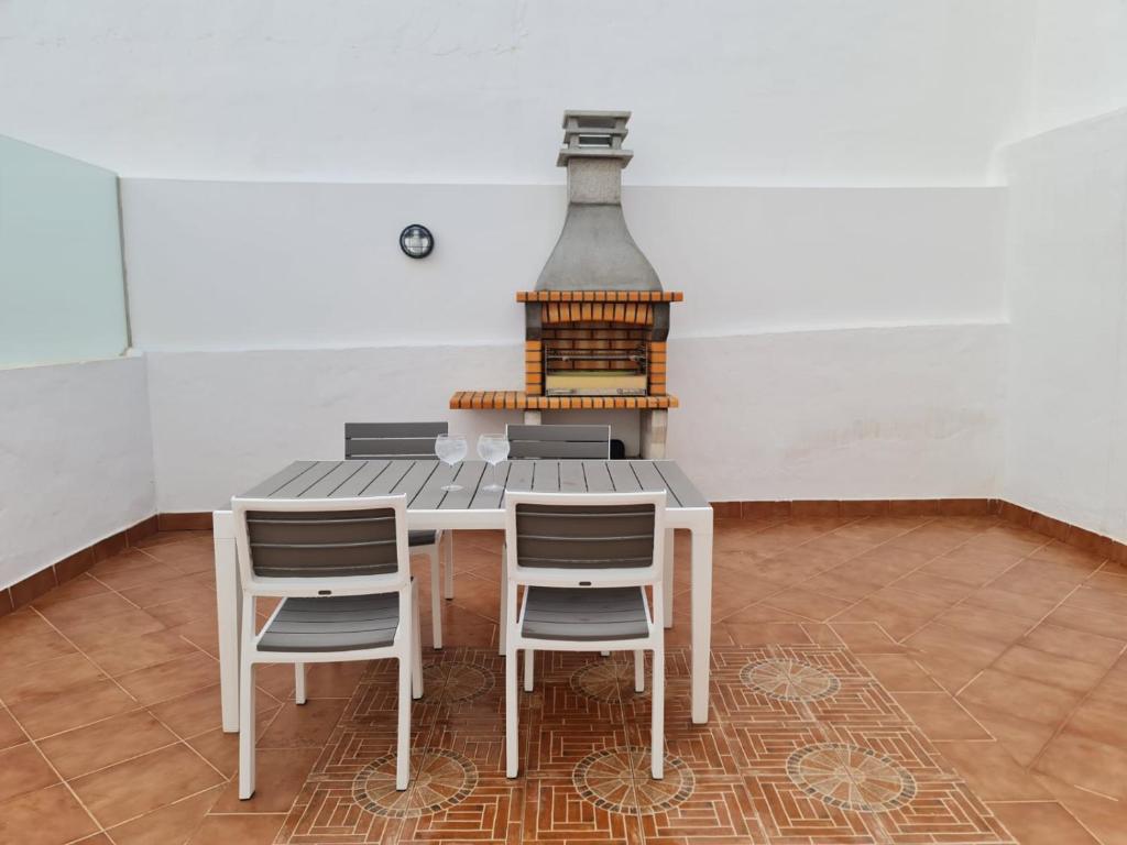 a table with chairs and a stove in a room at El Olivar La Vega de Tetir in Tetir