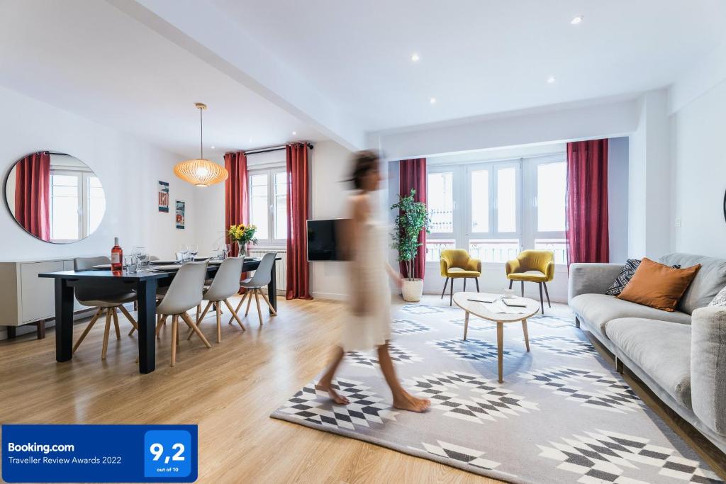 a woman is walking through a living room at MARINA Suite Apartment in San Sebastián
