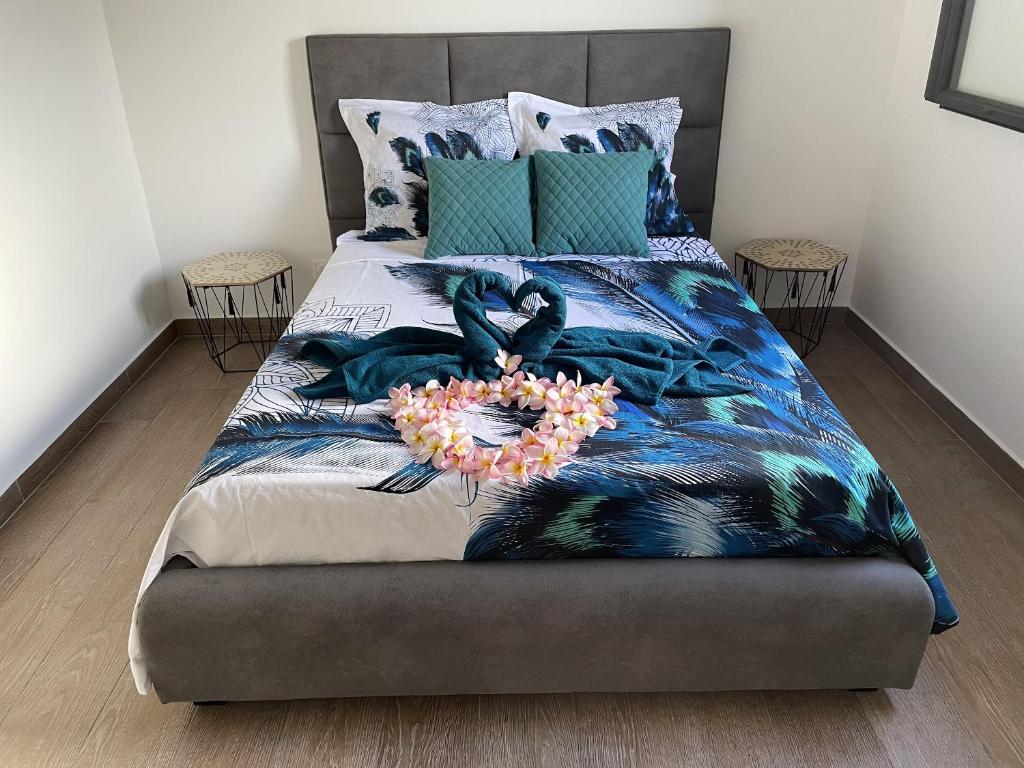 a bedroom with a bed with a flower arrangement on it at Villa confortable à Bras-Panon avec jardin convivial in Bras-Panon