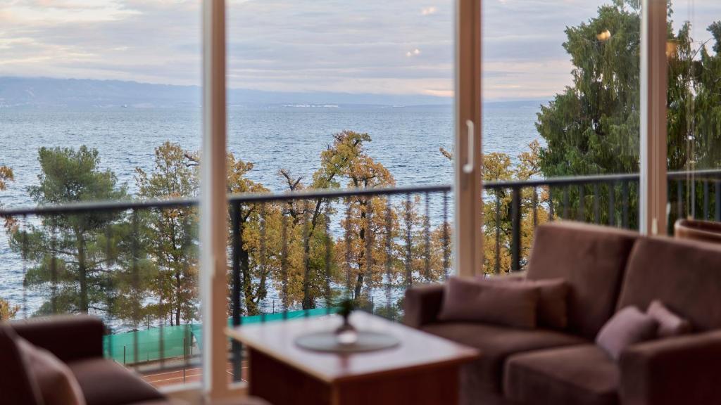 a view of the ocean from a room with a large window at Hotel Lovran in Lovran