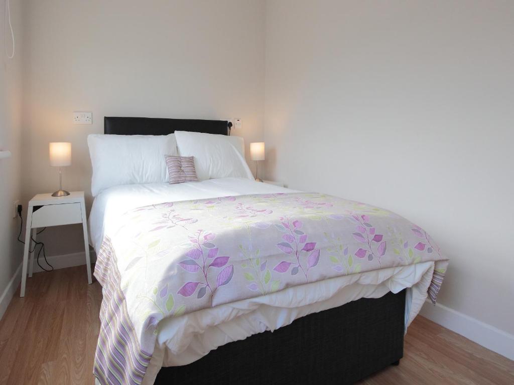 ダンガノンにあるThe Otton Suiteのベッドルーム1室(紫と白の掛け布団付きのベッド1台付)