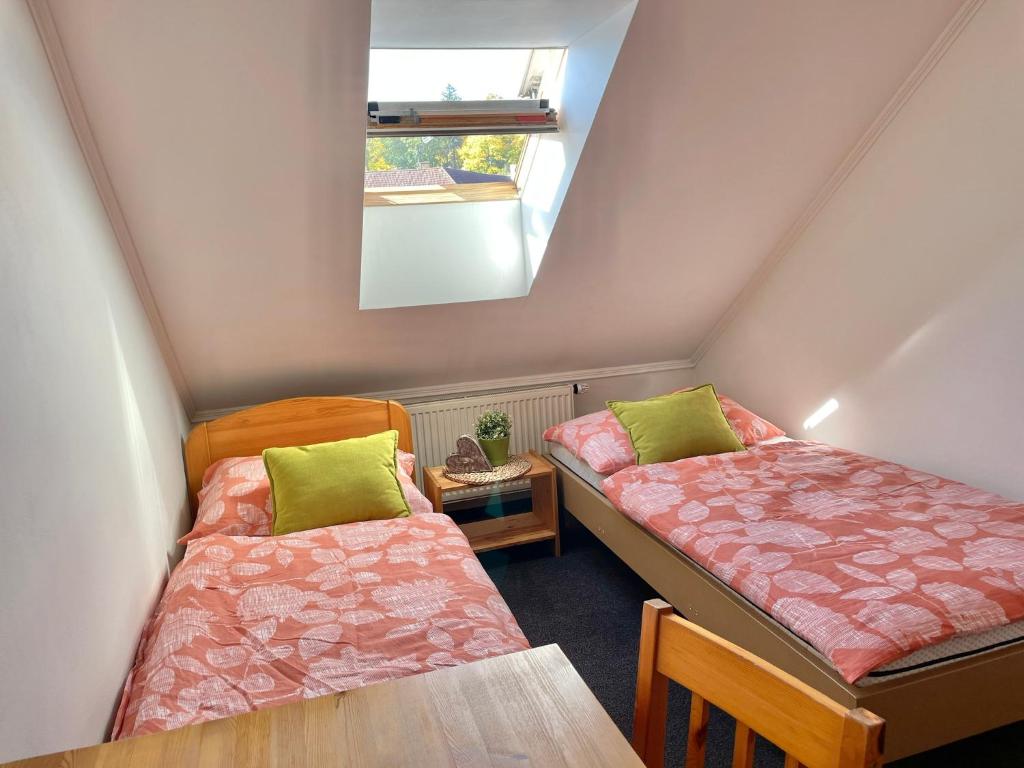 a attic room with two beds and a table at Penzion Brtnice in Brtnice