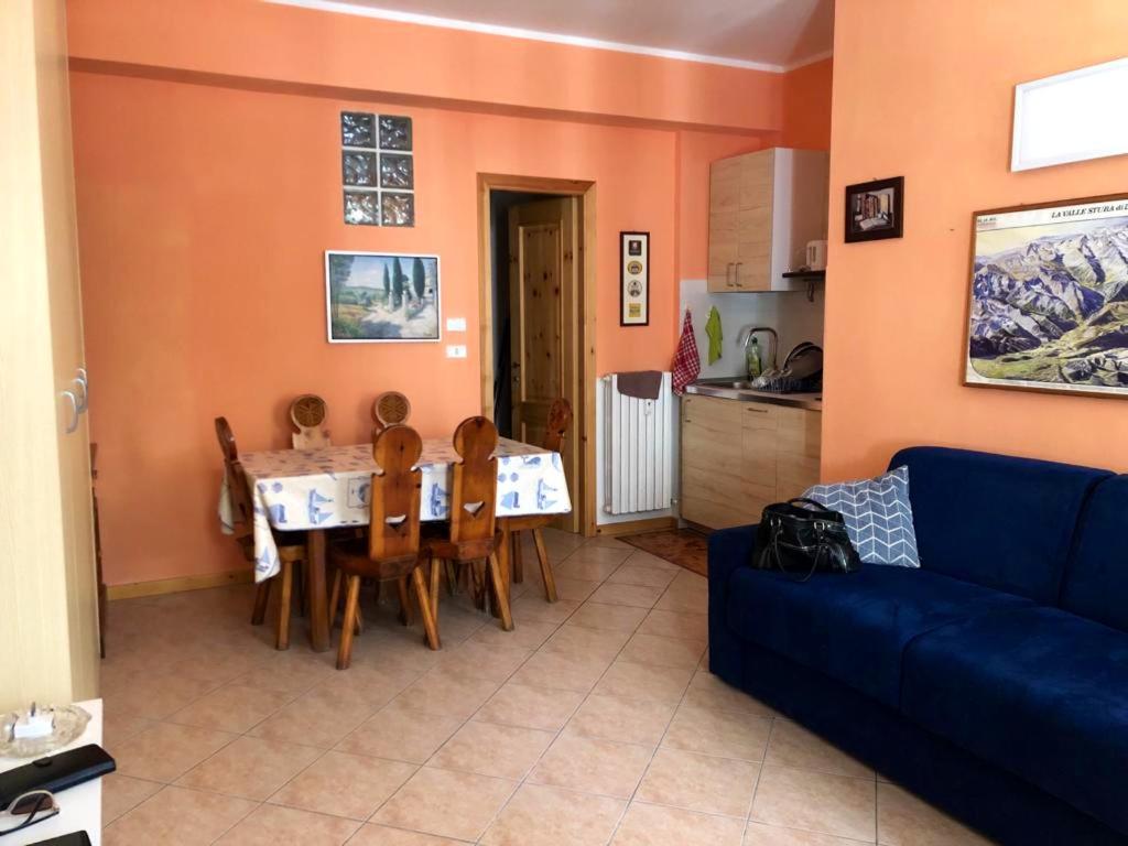 sala de estar con mesa y sofá azul en One bedroom apartement with terrace at Bersezio 1 km away from the slopes, 
