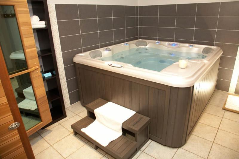 a bathroom with a bath tub with a towel in it at Le Bretagne - Hôtel Spa &amp; Sauna in Douarnenez