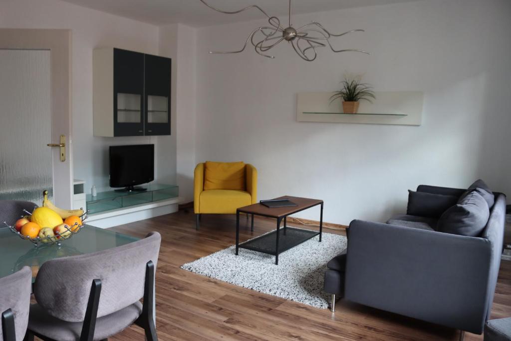 alexxanders Apartments & Studios في شيمنيتز: غرفة معيشة مع أريكة وطاولة
