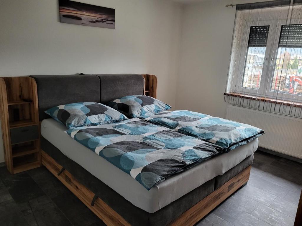 1 dormitorio con 1 cama con edredón azul y gris en Apartment Karin, Eigener Eingang, 3 Schlafzimmer, Doppelcarport, en Langenwang