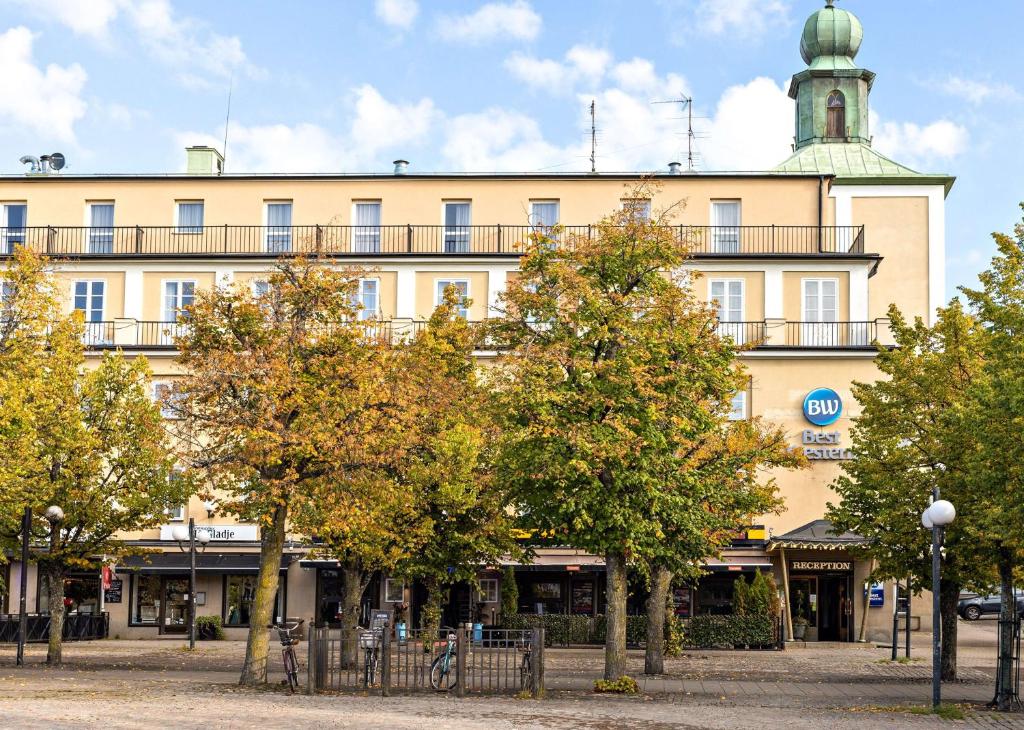 a large building with trees in front of it at Motala Stadshotell in Motala