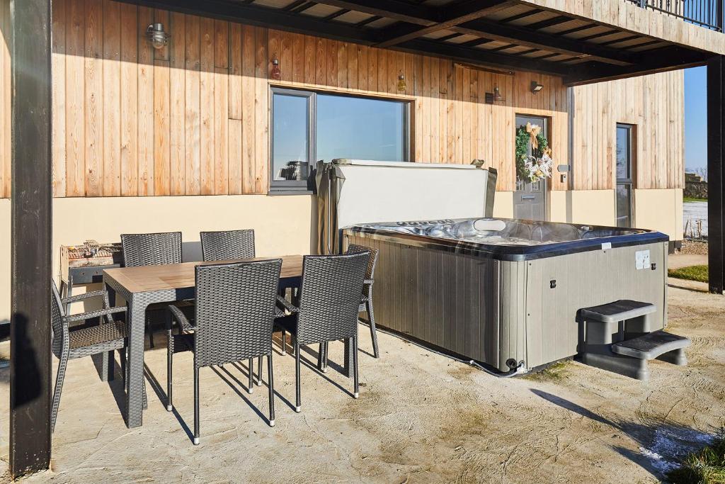 une terrasse avec un bain à remous, une table et des chaises dans l'établissement Host & Stay - High Bellridge Farm, à Kirkheaton