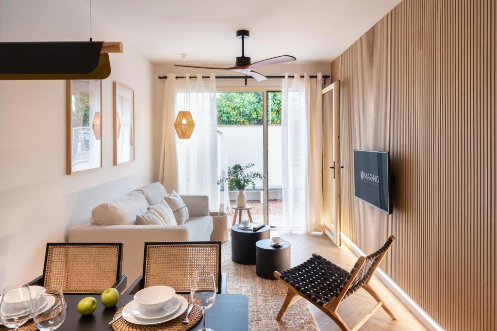 a living room with a couch and a table and chairs at Magno Apartments Robles with Bath Tub and Private Parking in Seville