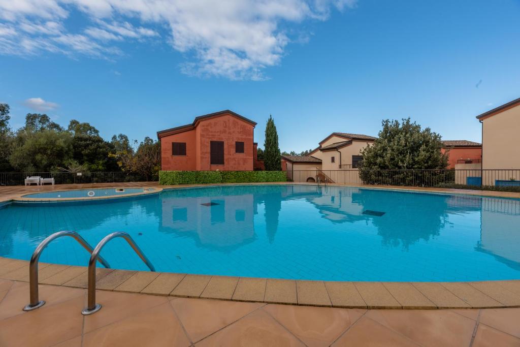 una grande piscina con un edificio sullo sfondo di A Muredda di Lozari a Belgodère