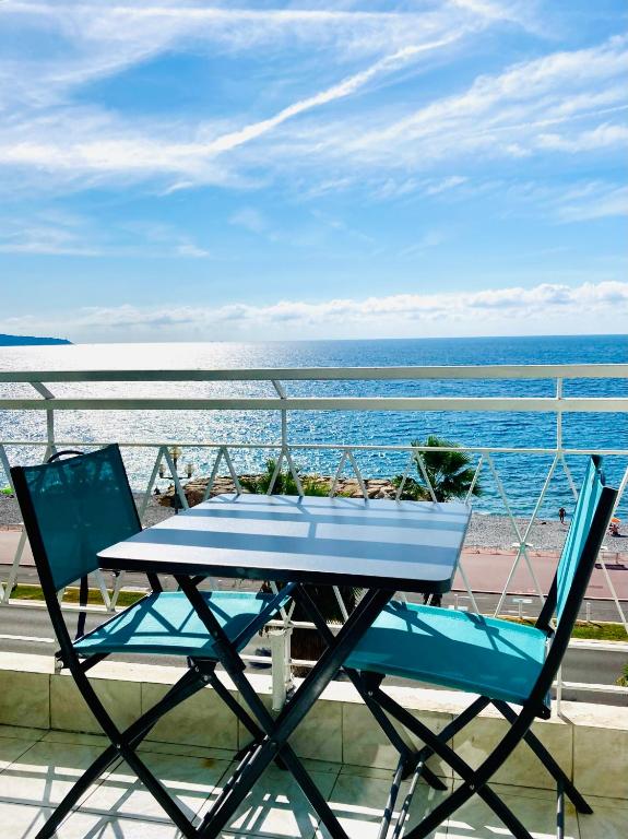 d'une table et de deux chaises sur un balcon donnant sur l'océan. dans l'établissement Residence le Florence, à Nice