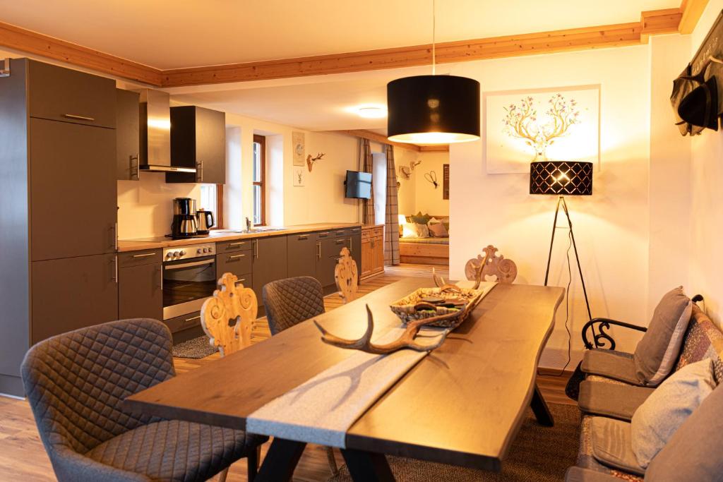 kuchnia i jadalnia z drewnianym stołem i krzesłami w obiekcie Appartements Kirchenwirt w mieście Kirchberg in Tirol
