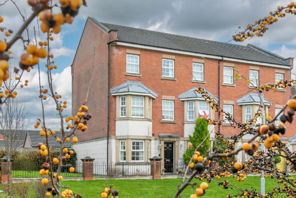 an orange tree in front of a brick house at The Fusiliers in Leyland