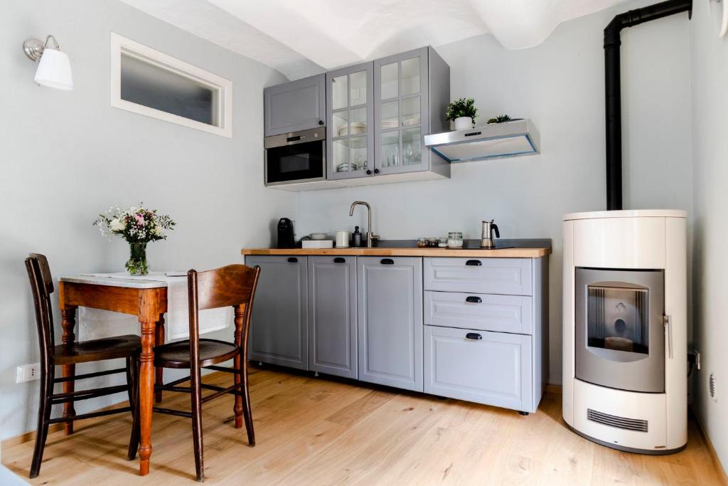 een keuken met een fornuis, een tafel en een koelkast bij Lindhouse - Country House a Govone in Govone