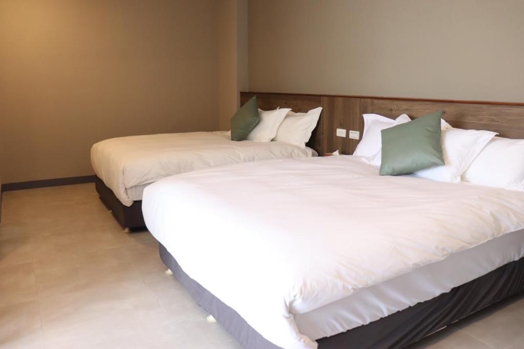 duas camas sentadas uma ao lado da outra num quarto em Rooms Homestay em Hualien