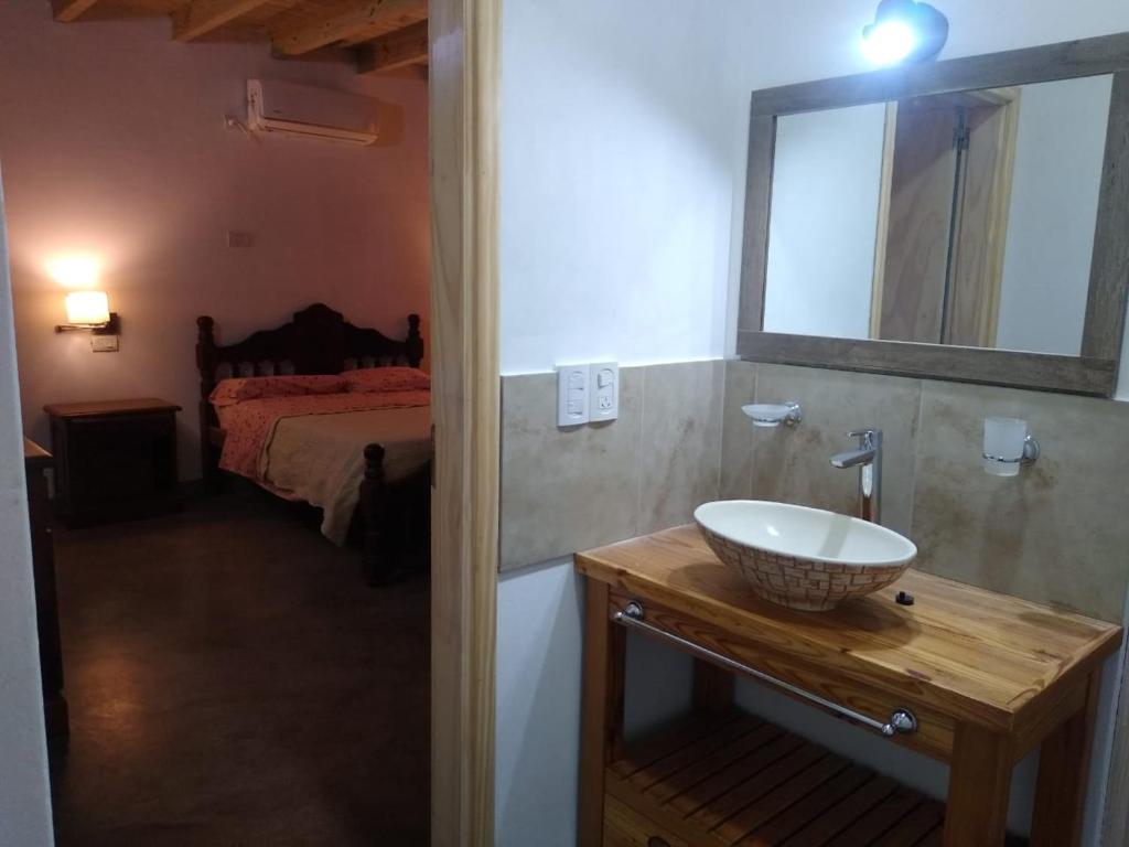 1 dormitorio con 1 cama y baño con lavabo. en El Candil en San Andrés de Giles