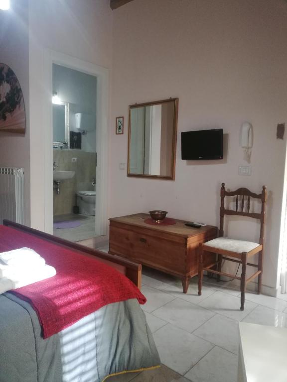 sypialnia z łóżkiem, lustrem i krzesłem w obiekcie B&B Parva Domus w mieście Lamezia Terme