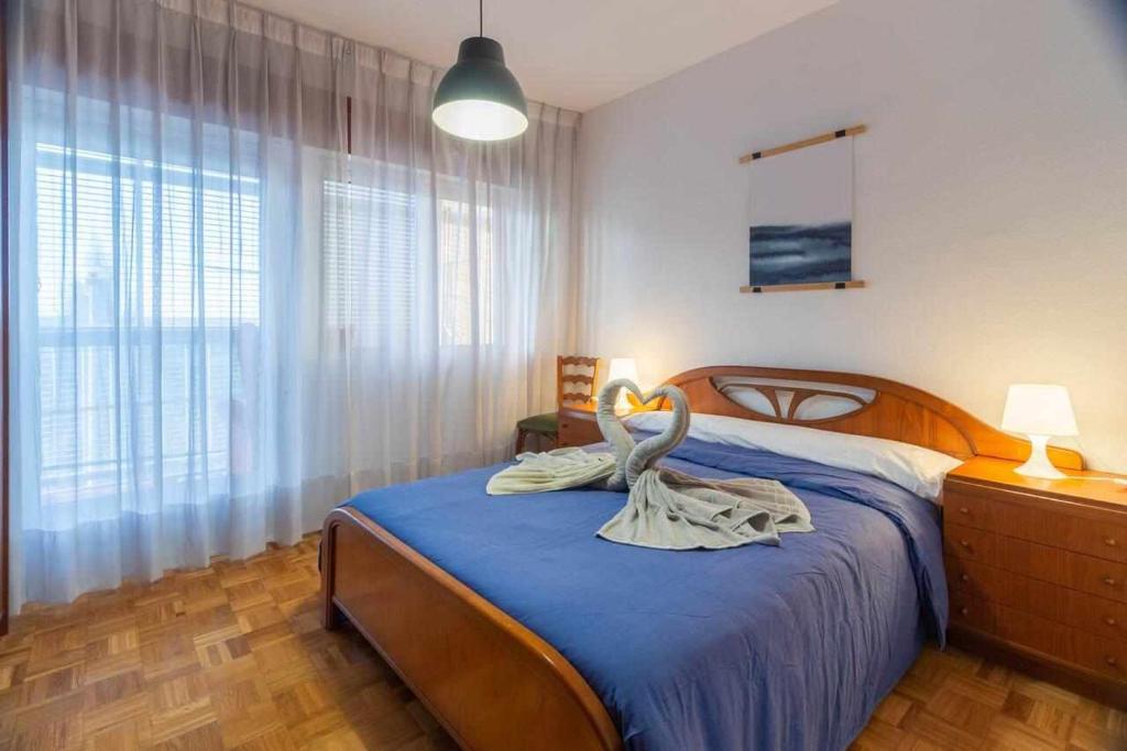 Hermanos Pinzón Apartamento في سمورة: غرفة نوم مع سرير وفوط بجعة عليه