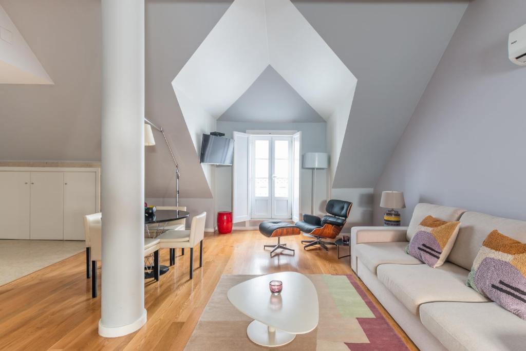 a living room with a white couch and a table at FLH Baixa-Chiado Library Loft in Lisbon