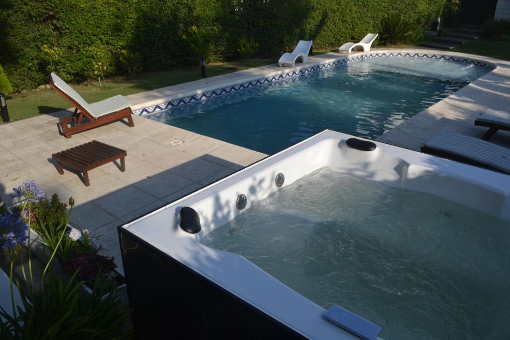 a swimming pool with a hot tub and a bench at Casa Simona Villa General Belgrano in Villa General Belgrano