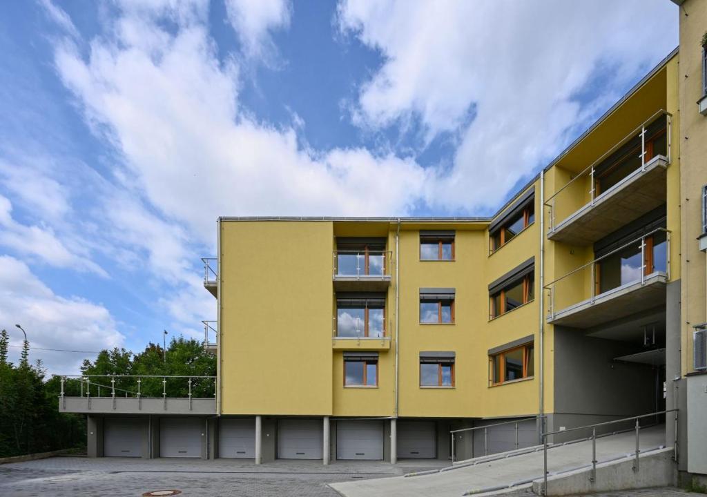 a yellow building with a sky in the background at EFI Residence Holzova 28 in Brno
