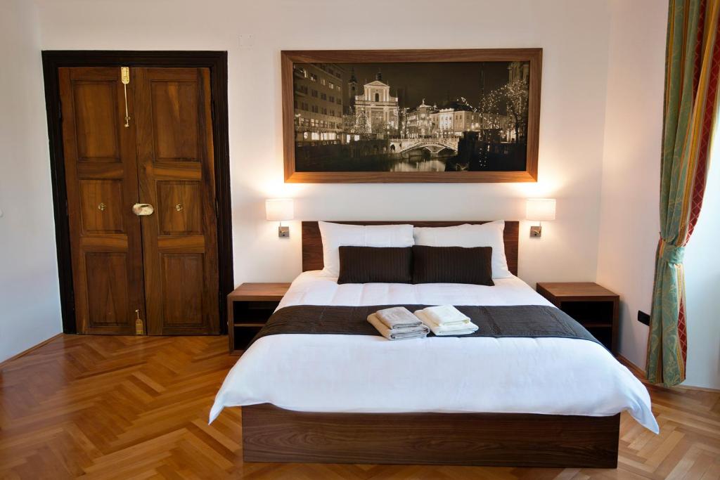 ein Schlafzimmer mit einem Bett mit zwei Büchern darauf in der Unterkunft Zois Apartments in Ljubljana