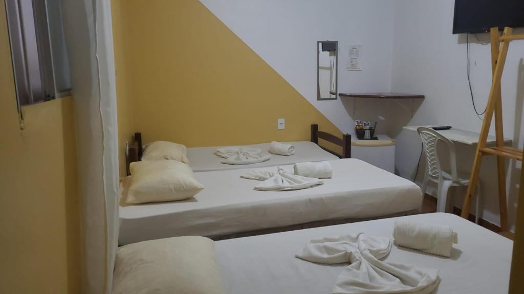 Habitación con 2 camas y sábanas blancas. en Pousada Descanso de Casa en João Pessoa