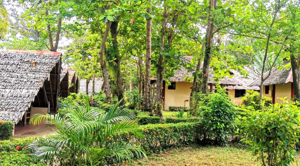 a house in the woods with trees and plants at Sulu Sunset Beach Resort in Nauhang