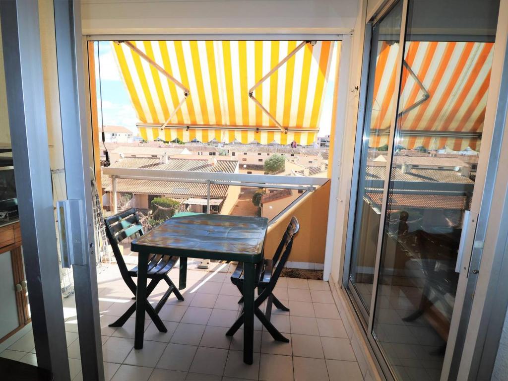 a table and chairs on a balcony with a view at Appartement Le Grau-du-Roi, 2 pièces, 4 personnes - FR-1-307-11 in Le Grau-du-Roi