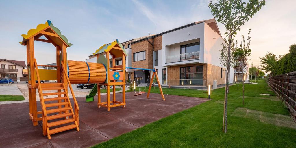 um parque infantil em frente a uma casa com escorrega em Royal Class Apart Complex Uno Residence em Brasov